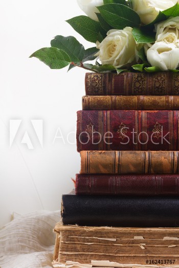 Picture of Old books with white flowers on romantic lace background close up